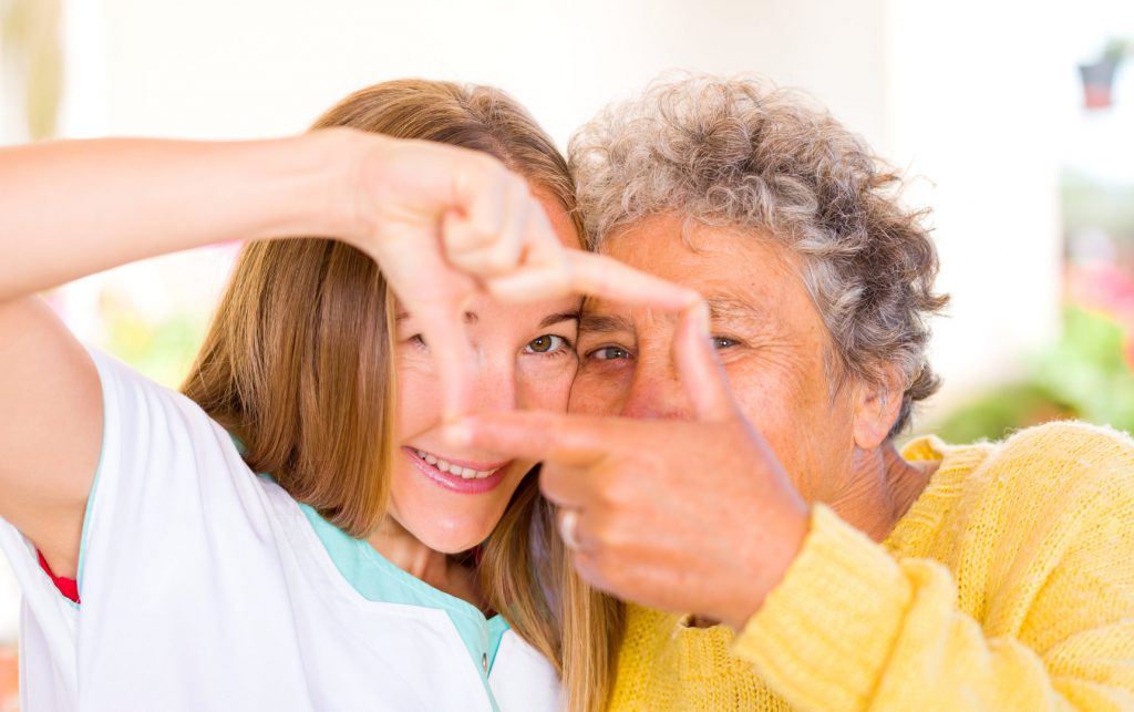 Rectangle avec les mains entre l'aide à domicile et l'aidé